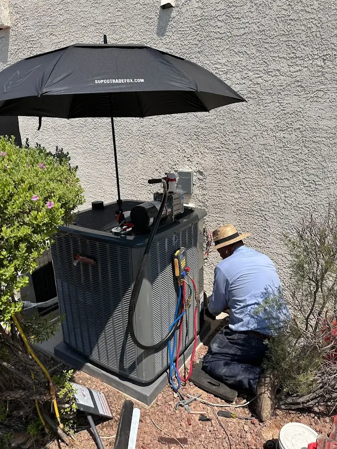 HVAC technician performing outdoor AC maintenance in Benton
